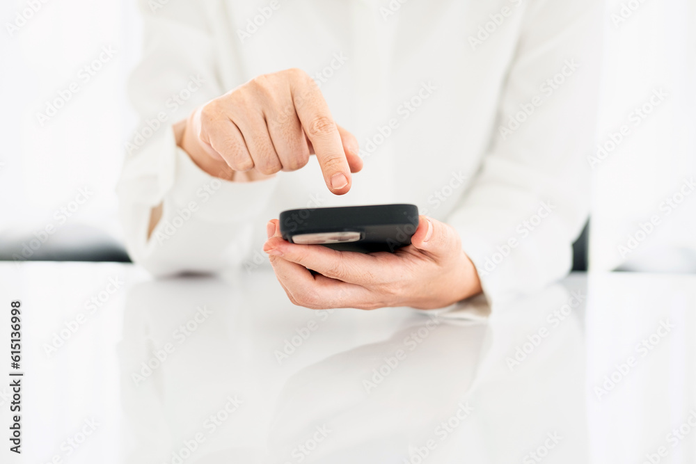 Woman with a finger on the screen using a mobile phone in the office