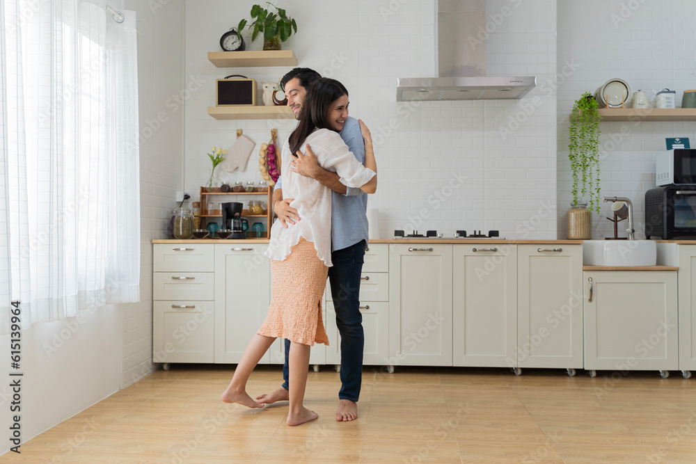 Romantic couple dancing in kitchen. Playful full length beautiful young couple in casual clothes dancing and smiling while standing in kitchen at home. Romantic couple dancing in kitchen. Playful full length beautiful young couple in casual clothes dancing and smiling while standing in kitchen at home.