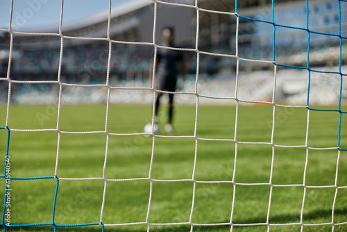 Young african american man holding soccer ball against soccer goal net