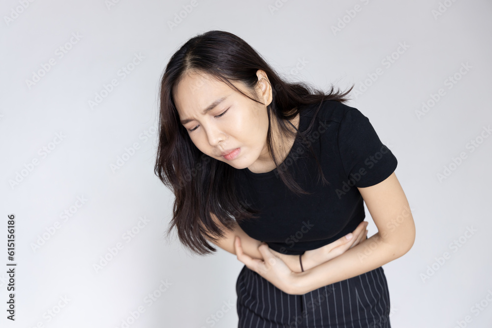 Asian woman with stomach ache, concept image of menstrual period cramp, abdominal pain, food poisoning, gastritis, acid reflux or colon cancer Asian woman with stomach ache, concept image of menstrual period cramp, abdominal pain, food poisoning, gastritis, acid reflux or colon cancer