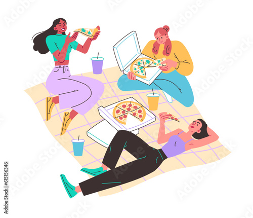 Girls in meadow on blanket eating pizza. Picnic, relaxing in nature