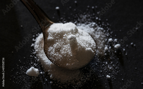 dose of white powder on a spoon. citrulline malate biohacking concept photo