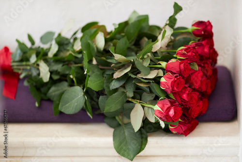 Fototapeta Naklejka Na Ścianę i Meble -  A lush bouquet of fresh red roses. Flower composition on light pastel background. Festive card concept, a place for text