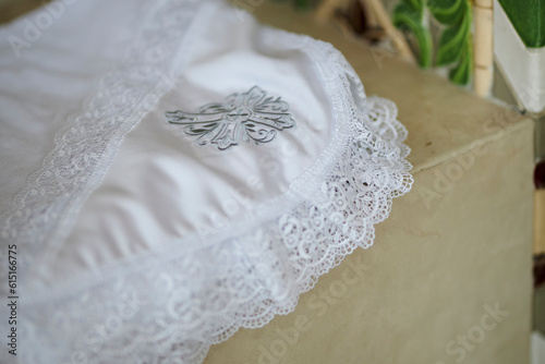 white towel for baptism in the temple. White baptismal towel with a cross. Cooking according to the traditional rite of baptism. Close-up