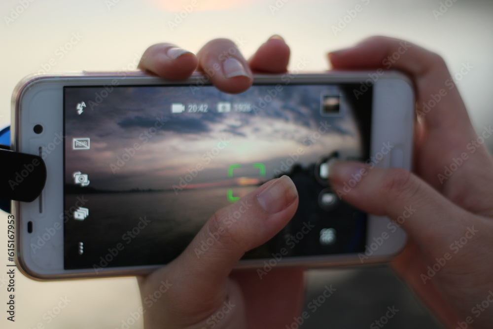 hands hold phone to take sunset photo︱focusing and light setting tips hands hold phone to take sunset photo︱focusing and light setting tips