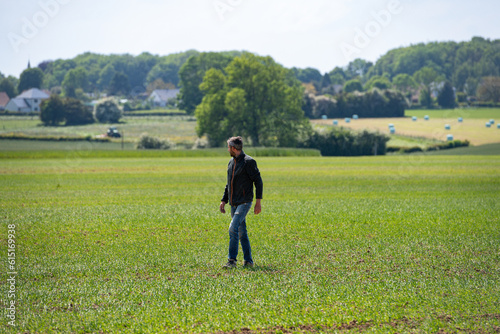 Jeune agriculteur inspectant un champ de blé. Paysage bucolique