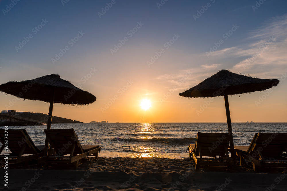 Sun loungers and parasol in sunset on Paros island, Greece Sun loungers and parasol in sunset on Paros island, Greece