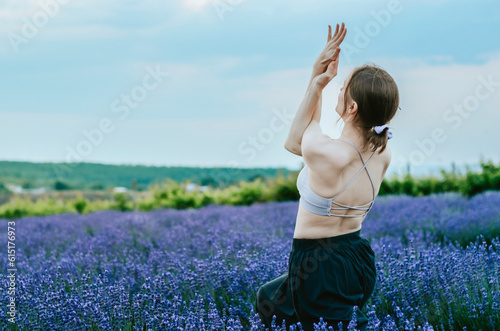 Fototapeta Naklejka Na Ścianę i Meble -  Side view of woman doing yoga in rural lavender field 