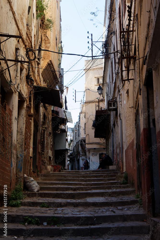 Algiers (Alger), Algeria, April 18 2023 : Street scene in the Casbah. Stone stairs and ancient ottoman houses. Chiaroscuro atmosphere. 