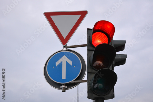 Traffic control signs and traffic light with red prohibitive color on the road pole on sky background