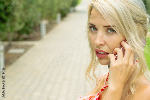 PRETTY GIRL SMILING WHILE IS TAKING A SELFIE AND CALLING BY PHONE IN THE STREET