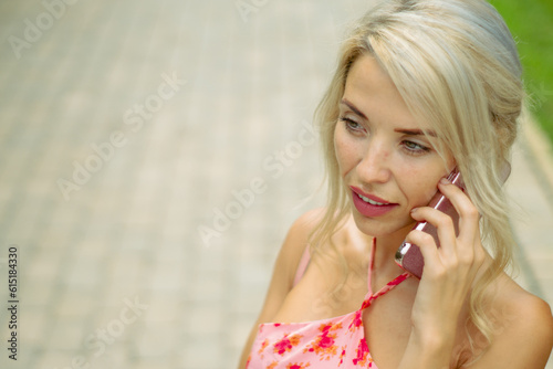 PRETTY GIRL SMILING WHILE IS TAKING A SELFIE AND CALLING BY PHONE IN THE STREET