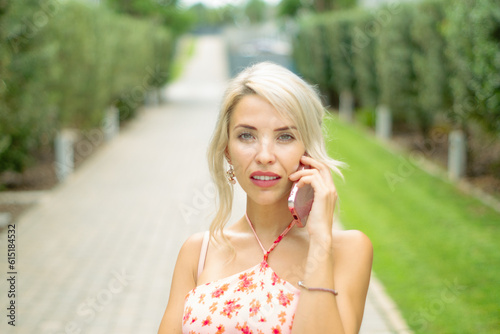 PRETTY GIRL SMILING WHILE IS TAKING A SELFIE AND CALLING BY PHONE IN THE STREET