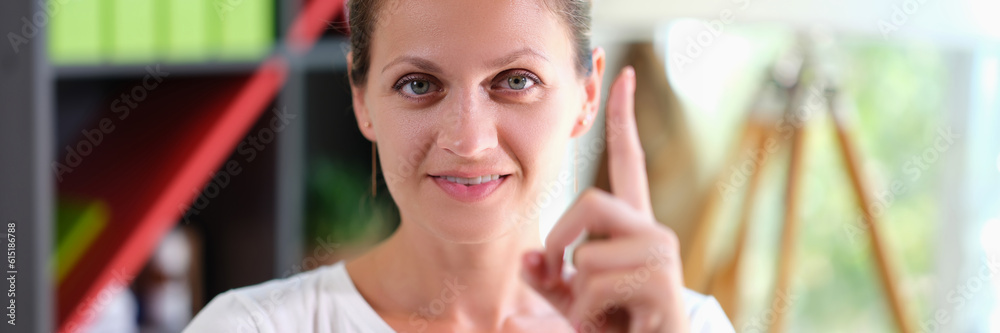 Portrait of happy smiling woman holding thumbs up