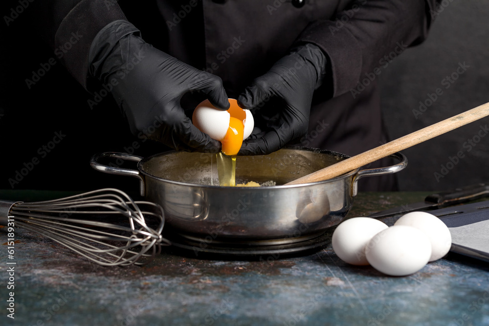 Cracking raw eggs into a bowl for making a cake