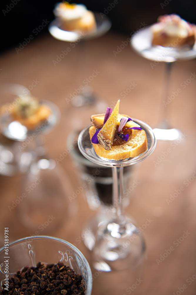 focus on gastronomic appetizer placed on a returned glass with a beautiful bokeh, original set up