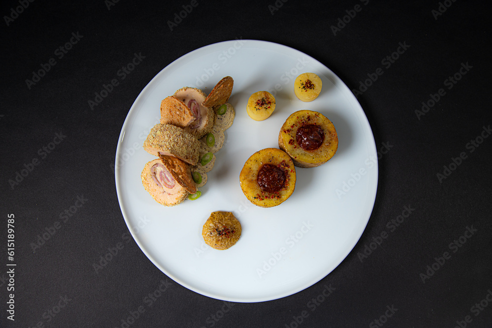 top view of a Gourmet and gastronomic chicken dish with potatoes isolated on a black background