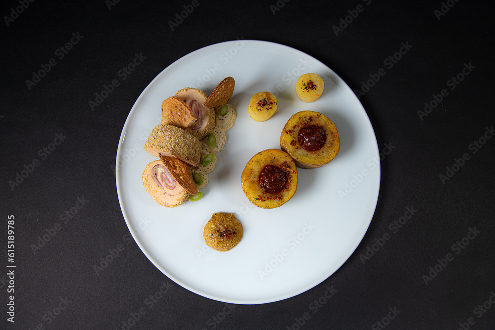 top view of a Gourmet and gastronomic chicken dish with potatoes isolated on a black background top view of a Gourmet and gastronomic chicken dish with potatoes isolated on a black background