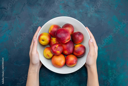 top view fresh mellow peaches inside plate on the dark-blue desk fruit fresh ripe mellow vitamine