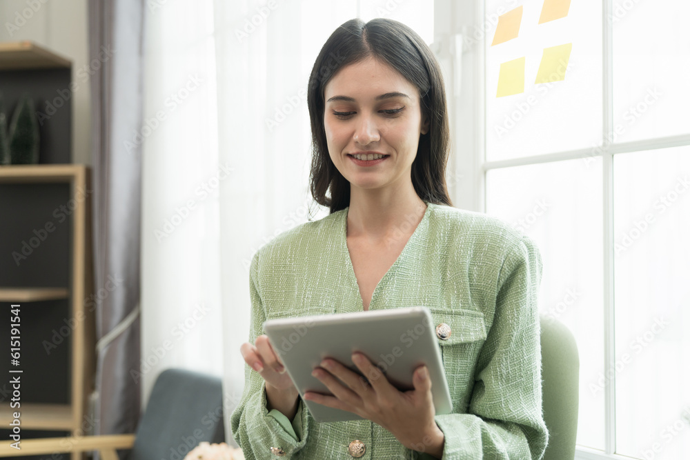 Happy young business woman using digital tablet in office. Business people and office concept Happy young business woman using digital tablet in office. Business people and office concept