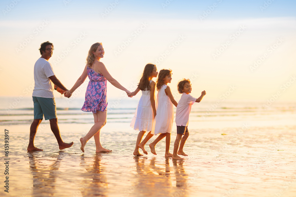 Family walking on tropical beach at sunset