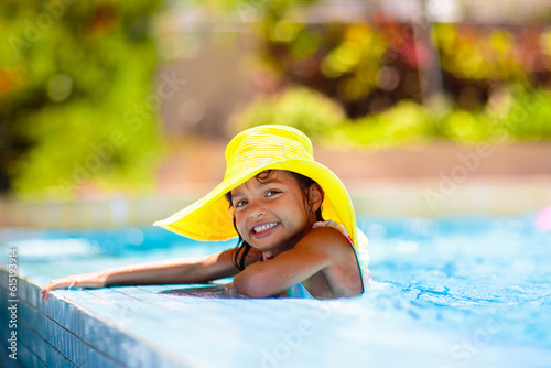 Child in swimming pool on ring toy. Kids swim. © famveldman