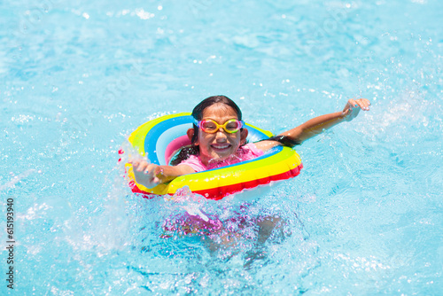Child in swimming pool on toy ring. Kids swim. © famveldman