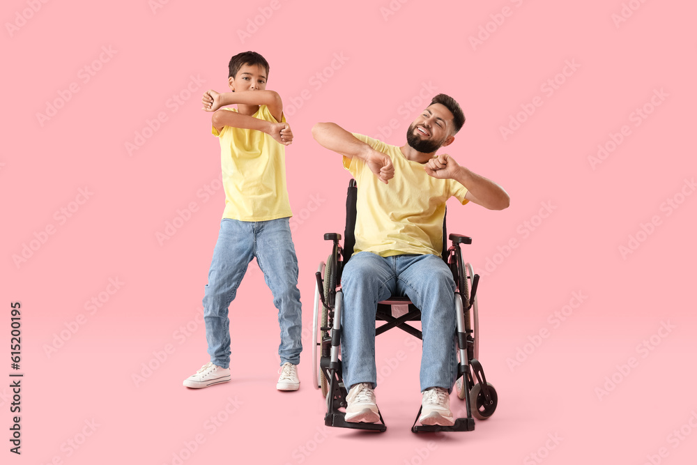 Fototapeta premium Little boy and his father in wheelchair dancing on pink background