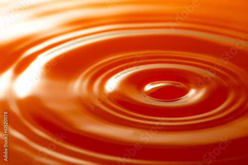 Macro orange drop,Macro orange water drop texture,Falling drop in orange water with splash,The waves after a few drops of orange juice