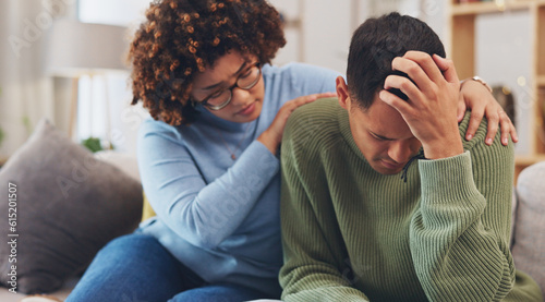 Couple, depression and woman comfort man with empathy, support and love while sitting in living room at home. Grief, loss with mental health and sad, stress and people in relationship in crisis