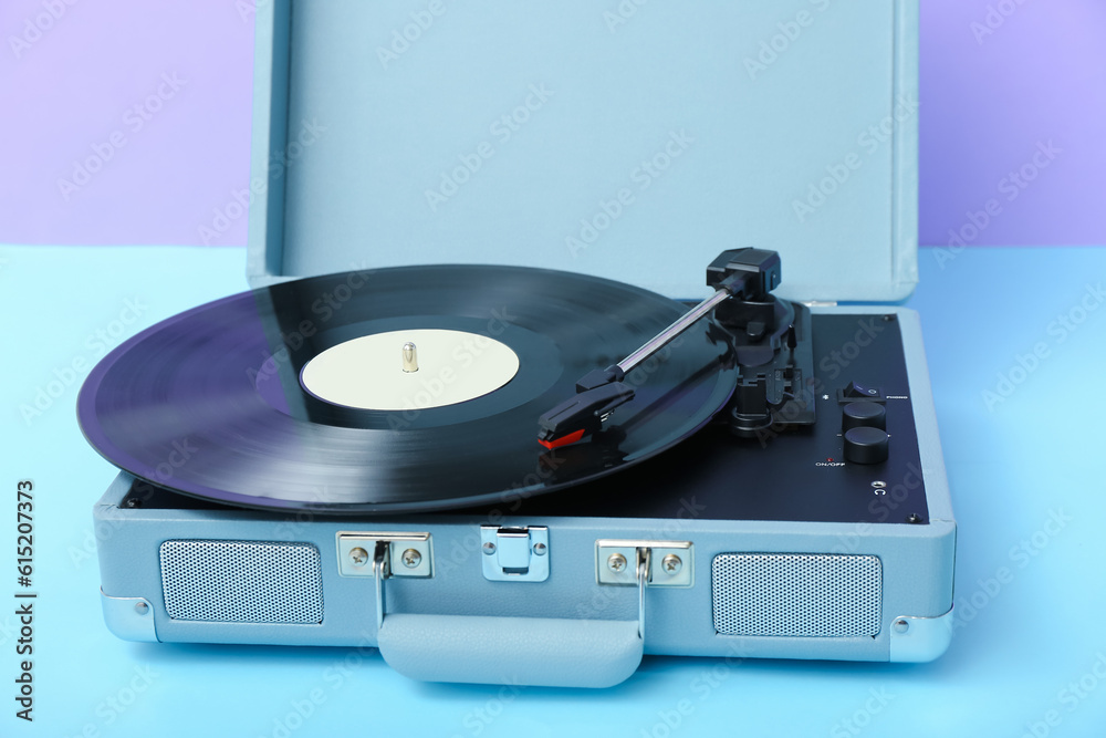 Record player with vinyl disk on table near lilac wall Record player with vinyl disk on table near lilac wall
