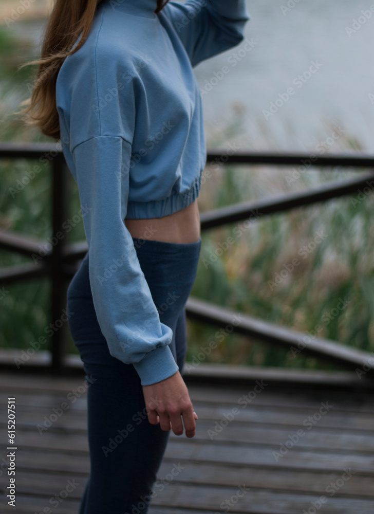 View of athletic body of a girl in blue gym suit .