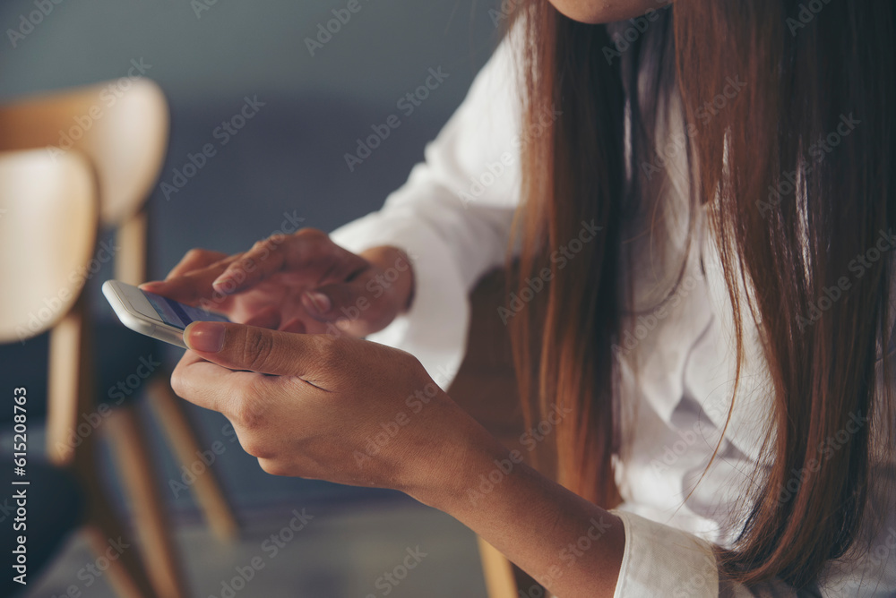 Woman hand using smartphone. Person side view of asian sad girl typing mobile phone at cafe. Technology concept.