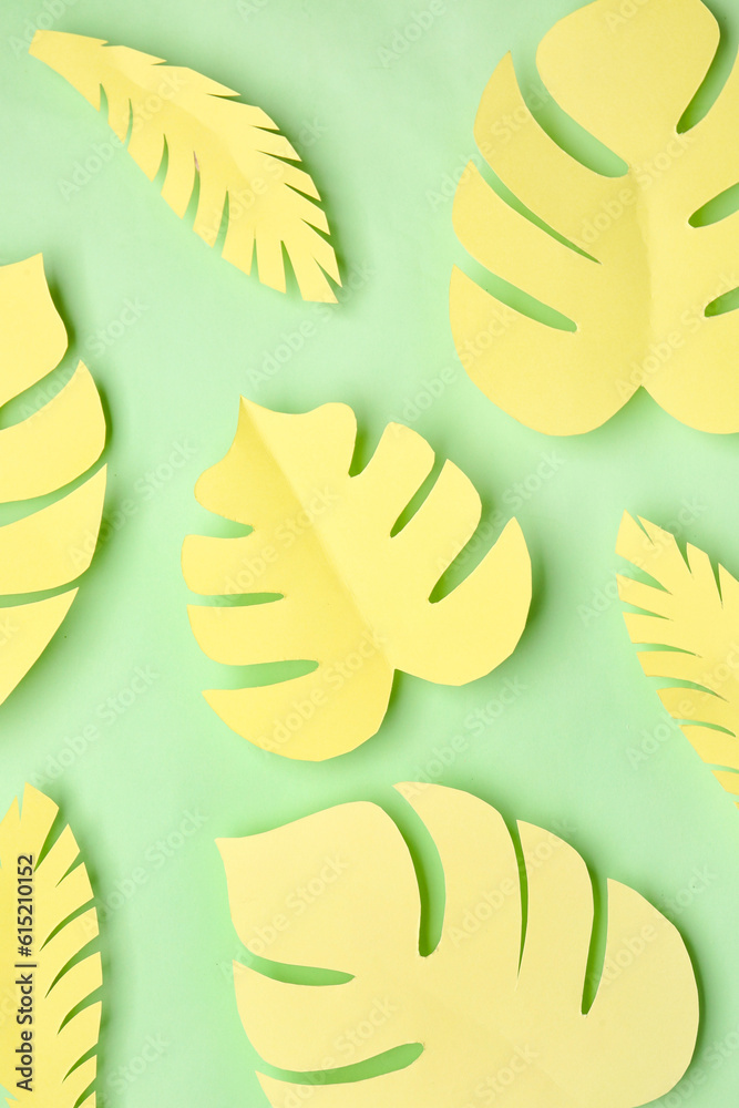 Yellow paper tropical leaves on green background Yellow paper tropical leaves on green background