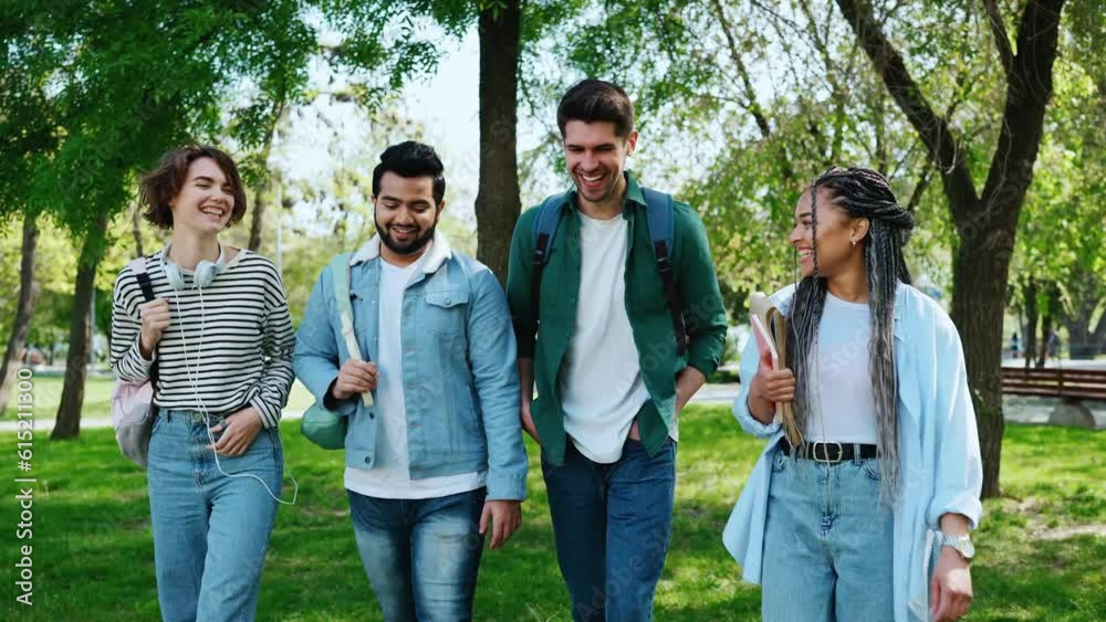 Happy multicultural young student friends talking and walking in park Happy multicultural young student friends talking and walking in park
