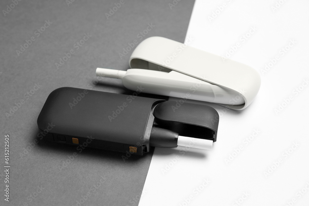 Different electronic cigars with sticks on white and black background Different electronic cigars with sticks on white and black background