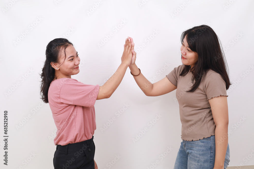 Two asian women meeting greeting giving high five clapping hands isolated on white background Two asian women meeting greeting giving high five clapping hands isolated on white background