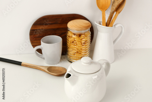 Composition with teapot, cup and different items on white table