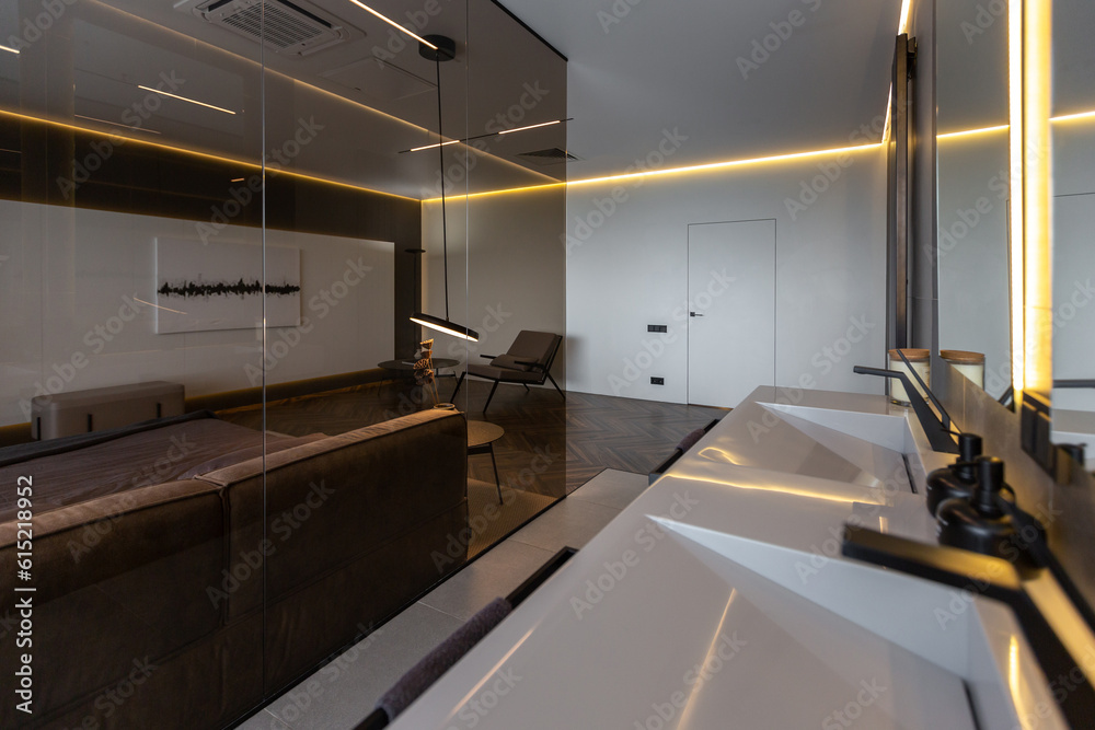 cool expensive interior design of room in prestigious luxury hotel with dark tones with modern LED lighting and stylish furniture. the area with a sink is separated by dark glass from the bedroom cool expensive interior design of room in prestigious luxury hotel with dark tones with modern LED lighting and stylish furniture. the area with a sink is separated by dark glass from the bedroom
