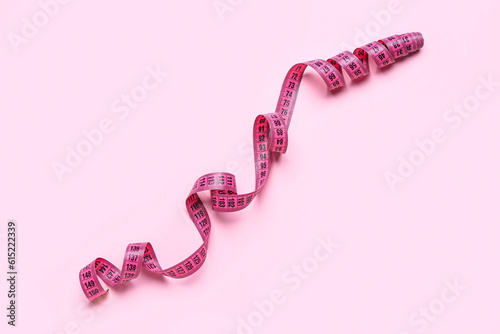 Measuring tape on pink background