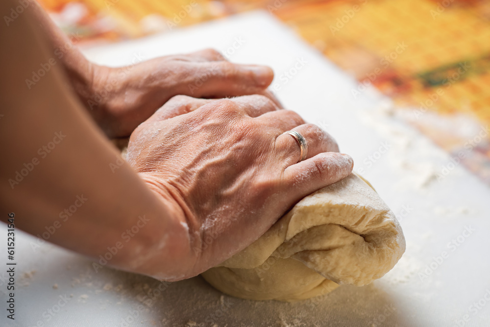 Unrecognizable woman kneading dough. Dough for dumplings, dumplings, pies.