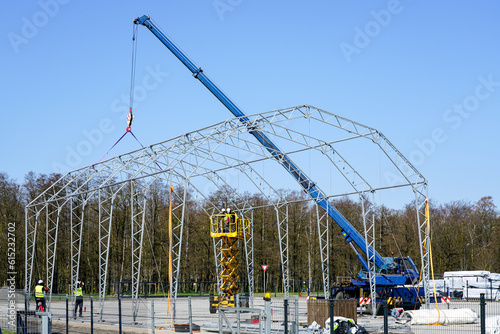 Assembly of the metal frame of the storage hangar with the help of a boom crane and a scissor lift photo