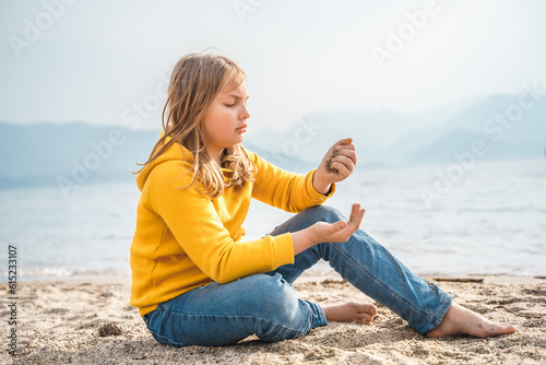 Fotografía Lonely beautiful sad girl teenager sits thoughtfully on sand sea beach