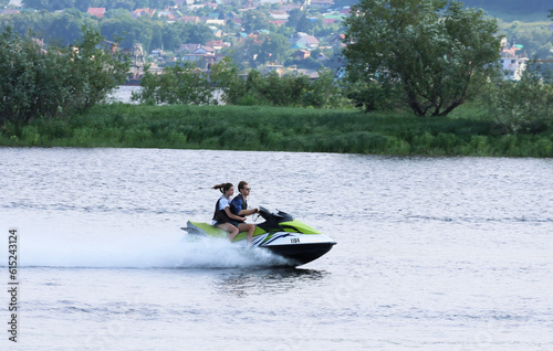 On a jet ski together, at high speed on the Volga River. A sunny summer day. Sports and recreation. © Alex