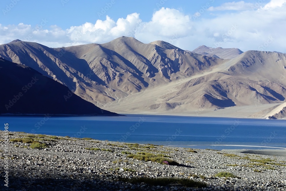 Mesmerizing sapphire-colored Lake Pangong in Indian Ladakh with majestic mountains as a stunning backdrop.
