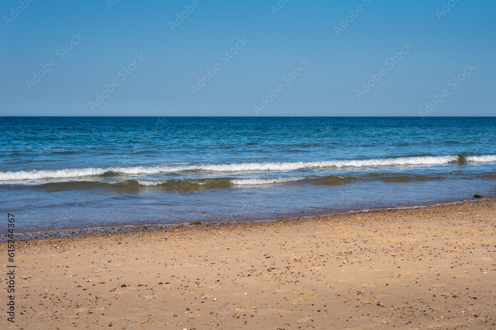 Photo of a sandy beach on a nice spring afternoon, use as a background