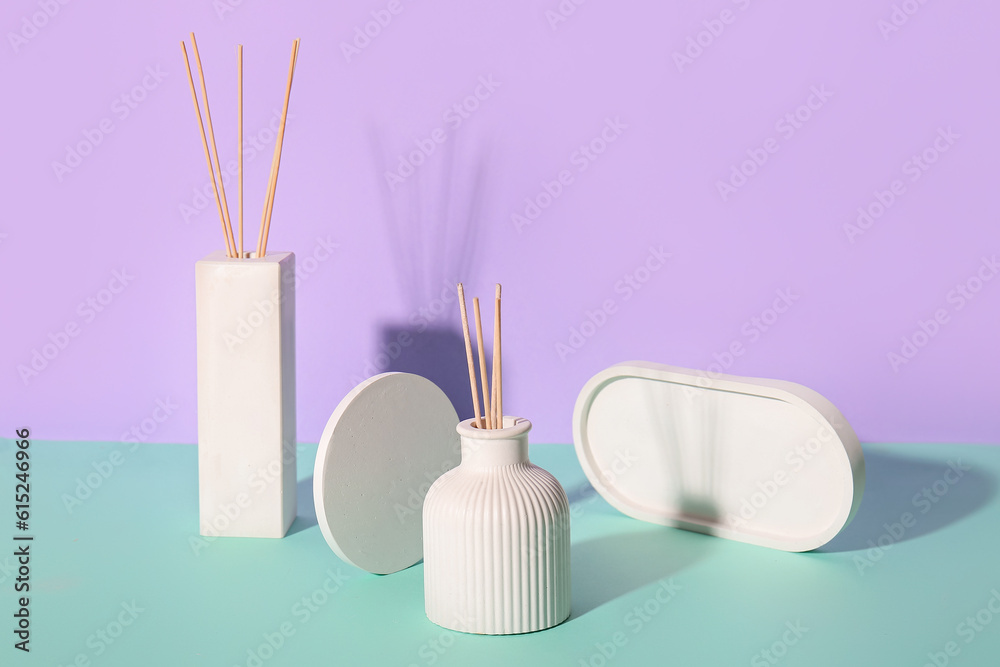 Bottles of reed diffuser on color background
