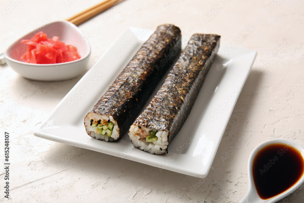 Plate with tasty maki rolls, ginger and soy sauce on light background Plate with tasty maki rolls, ginger and soy sauce on light background