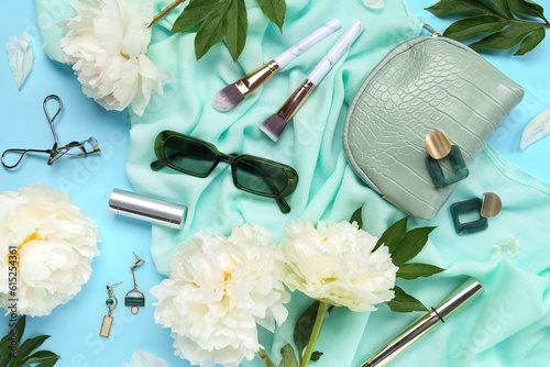 Composition with stylish female accessories, cosmetics and beautiful peony flowers on color background