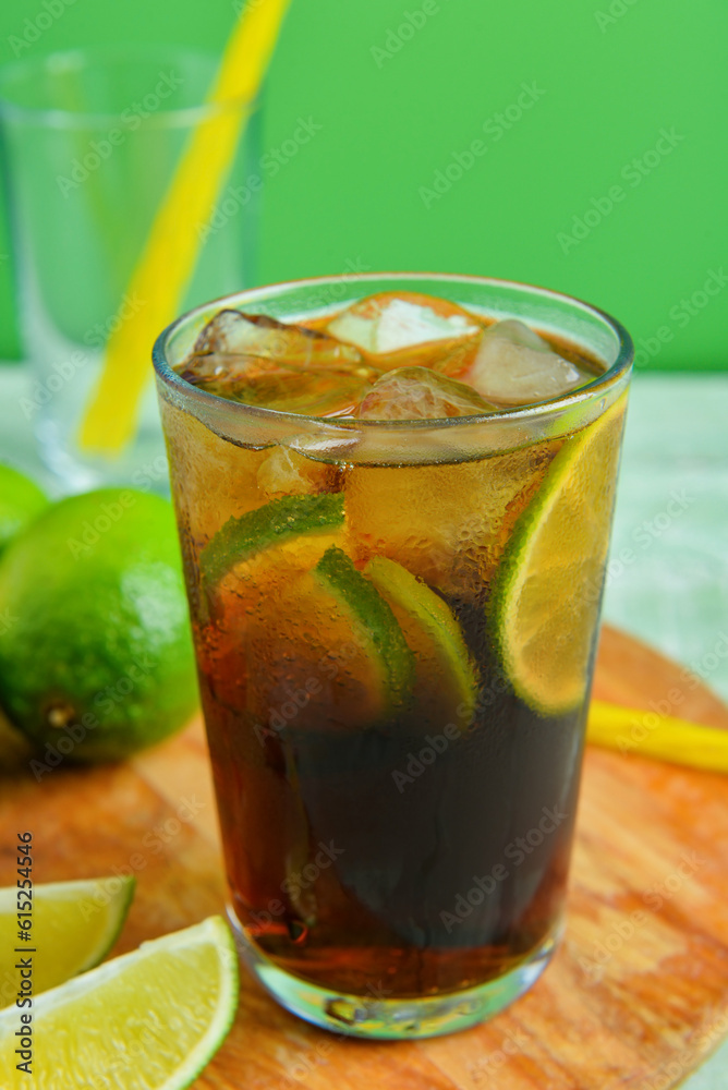 Board with glass of cold Cuba Libre cocktail, closeup Board with glass of cold Cuba Libre cocktail, closeup